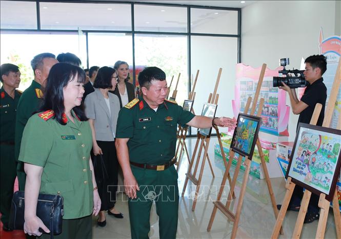 Các đại biểu tham quan triển lãm ảnh về hoạt động phòng tránh bom mìn ở Việt Nam. Ảnh: Trọng Đức - TTXVN