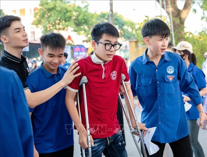 Tình nguyện viên hỗ trợ, động viên thí sinh có hoàn cảnh khó khăn trong kỳ thi tuyển sinh lớp 10 THPT năm học 2026 - 2027. Ảnh: TTXVN phát