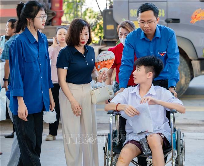 Tình nguyện viên hỗ trợ, động viên thí sinh có hoàn cảnh khó khăn trong kỳ thi tuyển sinh lớp 10 THPT năm học 2026 - 2027. Ảnh: TTXVN phát