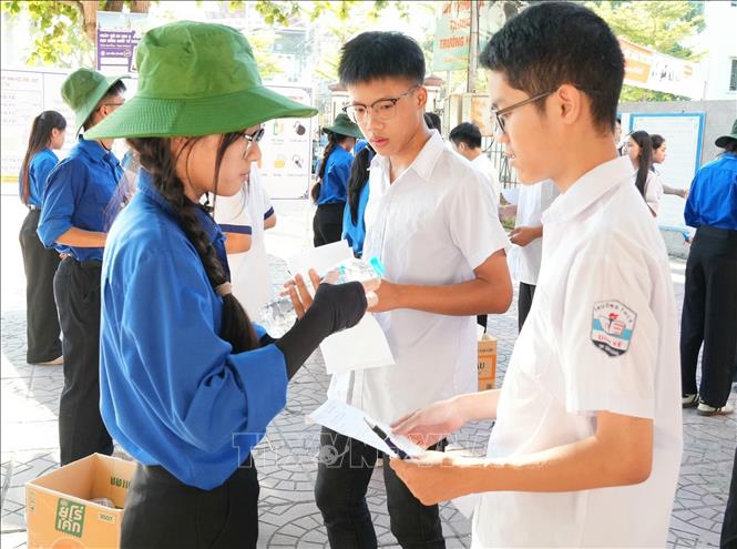 Đoàn viên, thanh niên tình nguyện hỗ trợ thí sinh kiểm tra các vật dụng trước khi vào phòng thi để tránh sai sót. Ảnh: Đồng Thúy - TTXVN