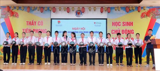 Ban tổ chức tặng mũ bảo hiểm cho học sinh Trường THCS Lương Khánh Thiện, phường Phù Liễn (Hải Phòng). Ảnh: Minh Thu - TTXVN