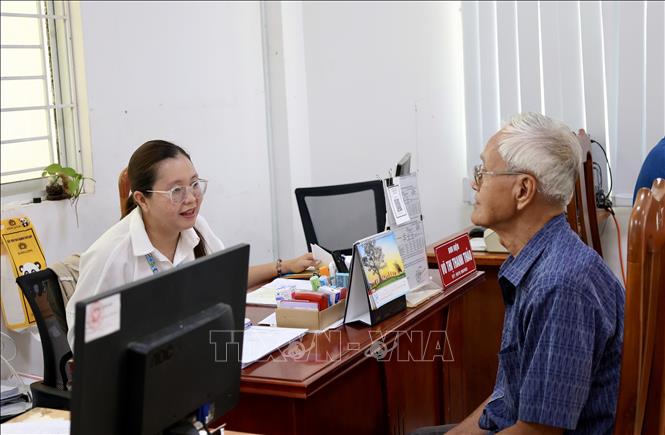 Cán bộ Trung tâm Phục vụ hành chính công phường Long Xuyên (An Giang) tận tình hướng dẫn người dân đến làm thủ tục hành chính. Ảnh: Thanh Sang - TTXVN