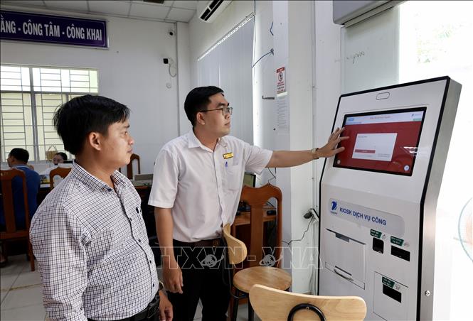 Cán bộ Trung tâm Phục vụ hành chính công phường Long Xuyên (An Giang) hướng dẫn người dân thực hiện thủ tục trực tuyến trên Cổng Dịch vụ công quốc gia. Ảnh: Thanh Sang - TTXVN