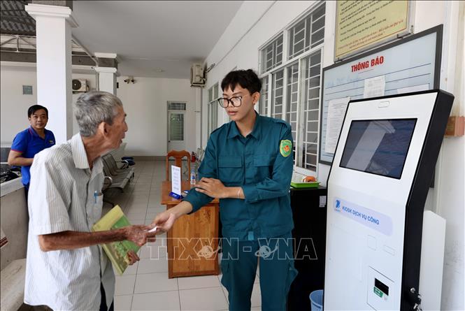 Người dân được hỗ trợ lấy số thứ tự và hướng dẫn quy trình làm thủ tục hành chính tại Trung tâm Phục vụ hành chính công phường Long Xuyên (An Giang). Ảnh: Thanh Sang - TTXVN