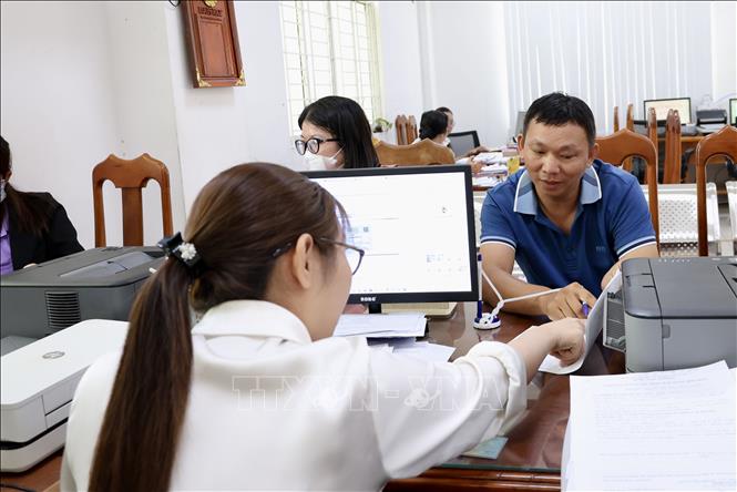 Cán bộ phường Long Xuyên, An Giang hướng dẫn người dân thực hiện các thủ tục hành chính. Ảnh: Thanh Sang - TTXVN