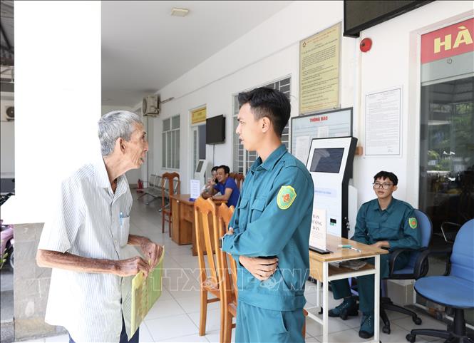Hướng dẫn người dân đến làm thủ tục hành chính tại Trung tâm Phục vụ hành chính công phường Long Xuyên (An Giang). Ảnh: Thanh Sang - TTXVN