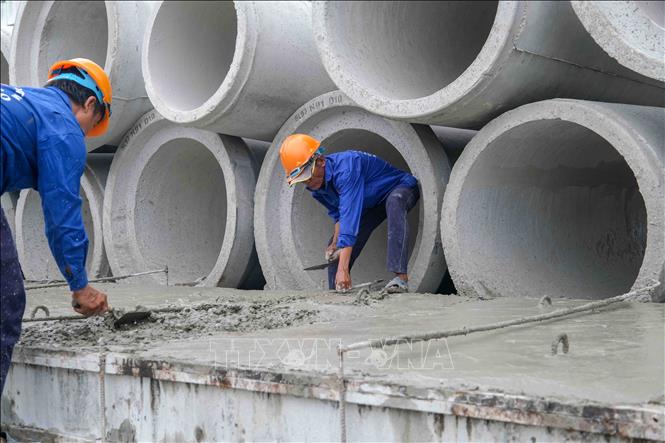 Công nhân thi công cống thoát nước trong khi chờ bàn giao mặt bằng dự án nâng cấp, mở rộng Quốc lộ 91 đoạn từ Km0 - Km7 với vốn đầu tư hơn 7.237 tỷ đồng. Ảnh: Thanh Liêm - TTXVN