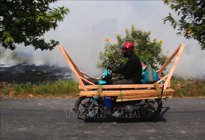 Xe gắn máy chở hàng công kềnh trên Đường tỉnh 931, xã Vĩnh Thuận Đông, thành phố Cần Thơ. Ảnh: Duy Khương – TTXVN