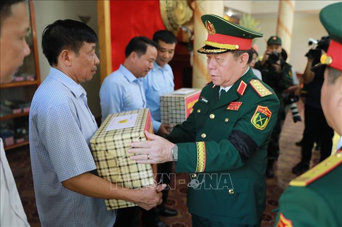 Đại tướng Nguyễn Trọng Nghĩa trao quà cho người dân. Ảnh: Nguyễn Nam-TTXVN 