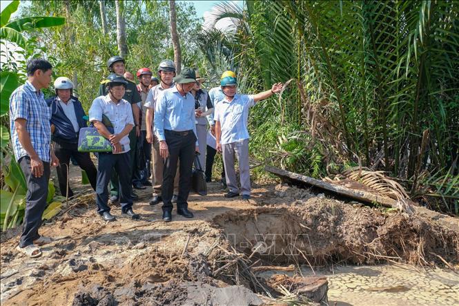 Lãnh đạo Sở Nông nghiệp và Môi trường thành phố Cần Thơ cùng chính quyền xã Nhơn Mỹ khảo sát một điểm sạt lở bờ sông Rạch Mọp. Ảnh: Thanh Liêm - TTXVN