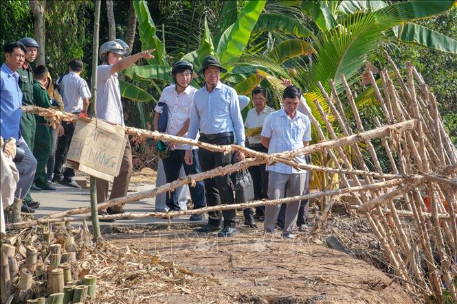 Lãnh đạo Sở Nông nghiệp và Môi trường thành phố Cần Thơ cùng chính quyền xã Nhơn Mỹ khảo sát một điểm sạt lở bờ sông Rạch Mọp. Ảnh: Thanh Liêm - TTXVN
