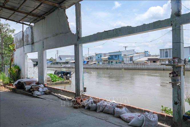 Một căn nhà ven kênh Xáng Nàng Mau (xã Thạnh Hòa, thành phố Cần Thơ) bị sạt lở chỉ còn lại những cây cột nằm sát mé sông. Ảnh: Thanh Liêm - TTXVN