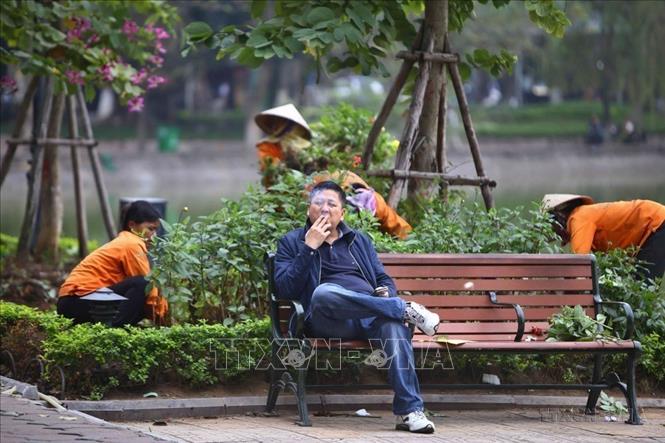 Một thanh niên vô tư hút thuốc lá tại khu vực công cộng quanh hồ Hoàn Kiếm. Ảnh: Minh Quyết - TTXVN