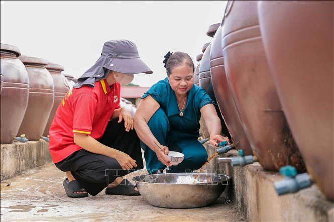 Kiểm tra chất lượng nước mắm thành phẩm tại Hợp tác xã Thu mua và Chế biến thủy hải sản Phú Khương. Ảnh: Hữu Quyết – TTXVN