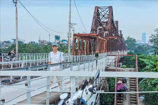 Xe máy, xe thô sơ và người đi bộ lưu thông trên mặt cầu được thảm mới. Ảnh: Hoàng Hiếu - TTXVN