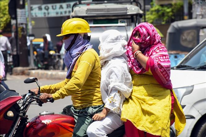 Người dân che chắn kĩ càng khi tham gia giao thông dưới thời tiết nắng nóng ở Kanpur, Ấn Độ. Ảnh: ANI/TTXVN