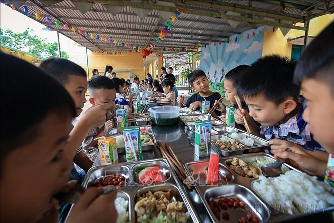 Trong không khí vui vẻ và ấm áp, các học sinh xóm Rằng (Hòa Bình) ăn suất cơm trưa bán trú ngon miệng. Ảnh: Trọng Đạt-TTXVN

