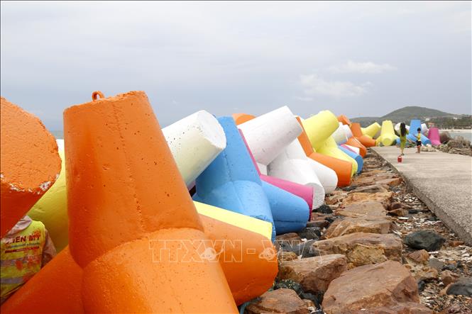 Các khối đá kè chắn sóng bãi biển đá Ông Địa được sơn nhiều màu sắc tạo nên điểm nhấn độc đáo thu hút du khách. Ảnh: Nguyễn Thanh - TTXVN