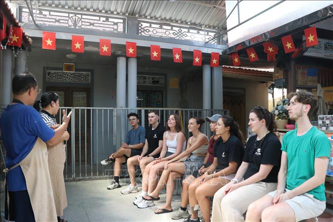 Du khách nước ngoài học ngôn ngữ ký hiệu trước khi trải nghiệm tại Trung tâm Hy vọng Huế. Ảnh: Mai Trang - TTXVN