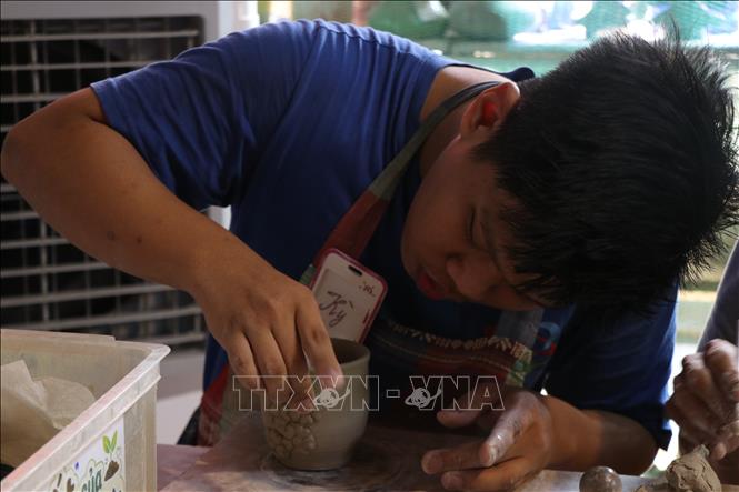 Học viên Trung tâm Hy vọng Huế học làm gốm. Ảnh: Mai Trang - TTXVN 