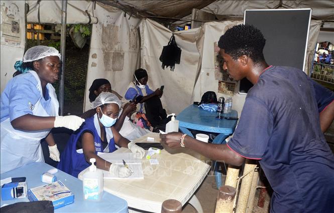 Nhân viên y tế lấy thông tin của hành khách nhập cảnh tại điểm kiểm soát biên giới Mpondwe, Uganda. Ảnh: THX/TTXVN