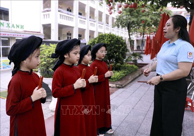Hoạt động truyền dạy hát Xoan ngoài sân Trường Tiểu học Gia Cẩm nơi cô và trò cùng thực hành những làn điệu dân ca gắn với di sản vùng đất Tổ. Ảnh: Hoàng Hùng – TTXVN