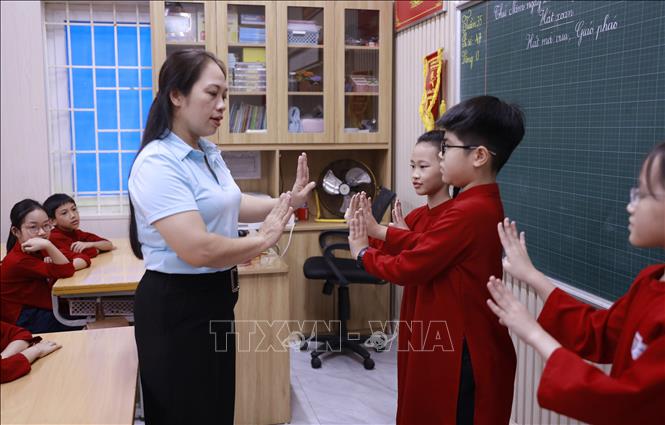 Cô Nguyễn Thị Hoàng Anh, Tổng phụ trách Đội Trường Tiểu học Gia Cẩm hướng dẫn học sinh chăm chú thực hành các động tác múa Xoan. Ảnh: Hoàng Hùng – TTXVN