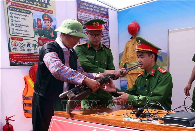 Người dân tự nguyện giao nộp vũ khí tự chế cho lực lượng Công an xã Vân Hồ. Ảnh: Phạm Kiên - TTXVN