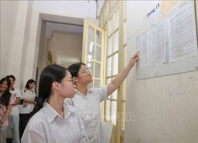 Thí sinh xem số báo danh của mình được niêm yết trước cửa phòng thi, điểm thi Trường THPT Trần Phú - Hoàn Kiếm (phường Cửa Nam). Ảnh: Thanh Tùng - TTXVN