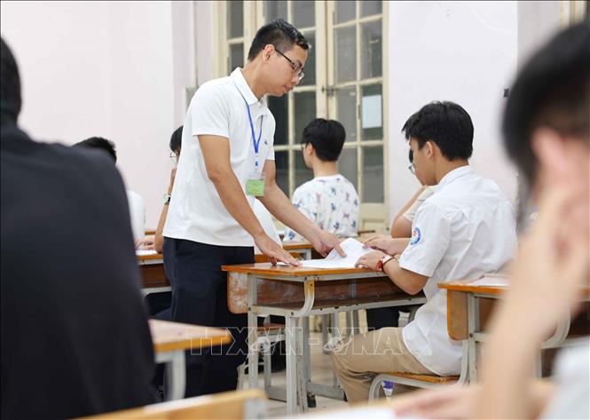 Giám thị kiểm tra thông tin, giải đáp thắc mắc của thí sinh. Ảnh: Thanh Tùng - TTXVN