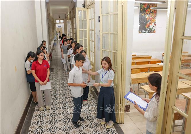 Giám thị gọi thí sinh vào phòng thi tại điểm thi Trường THPT Trần Phú - Hoàn Kiếm (phường Cửa Nam) để làm thủ tục dự thi. Ảnh: Thanh Tùng - TTXVN