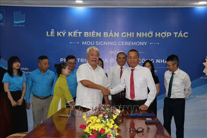 Ông Võ Khắc Thái, Phó Chủ tịch thường trực Liên đoàn Lao động Thành phố Hồ Chí Minh (trái) cùng ông Nguyễn Văn Lợi, Giám đốc Công ty Cổ phần Sản xuất Xây dựng Thanh Bình thực hiện nghi thức ký kết thoả thuận hợp tác. Ảnh: Thanh Vũ-TTXVN 
