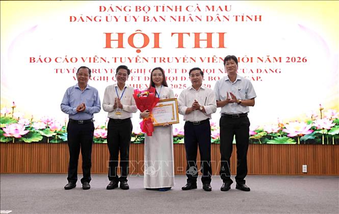 Ban Tổ chức trao thưởng cho thí sinh Sử Huỳnh Anh, đơn vị Đảng ủy Trường Cao đẳng Cộng đồng, xuất sắc đoạt giải Nhất. Ảnh: Chanh Đa - TTXVN