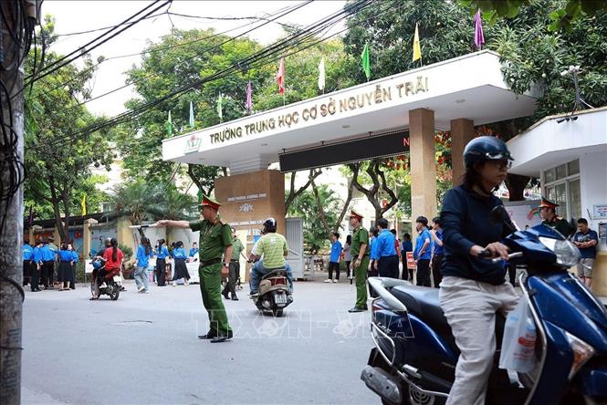 Lực lượng Công an phường Khương Đình làm nhiệm vụ đảm bảo an ninh trật tự, an toàn giao thông tại điểm thi Trường THCS Nguyễn Trãi. Ảnh: Phạm Kiên - TTXVN