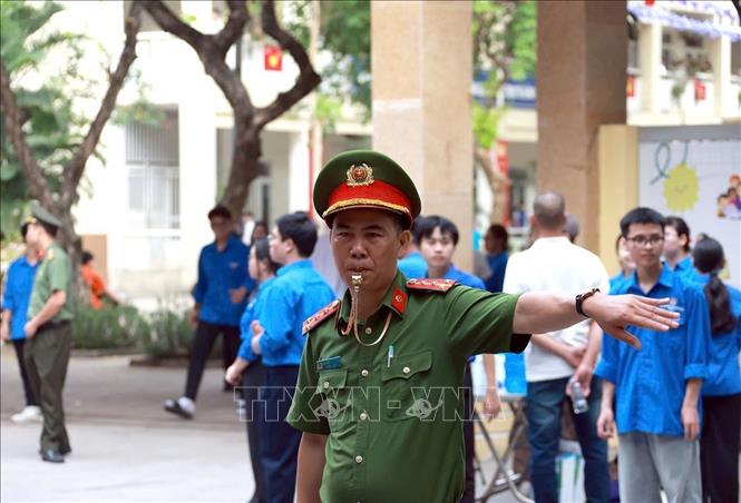 Lực lượng Công an phường Khương Đình làm nhiệm vụ đảm bảo an ninh trật tự, an toàn giao thông tại điểm thi Trường THCS Nguyễn Trãi. Ảnh: Phạm Kiên - TTXVN