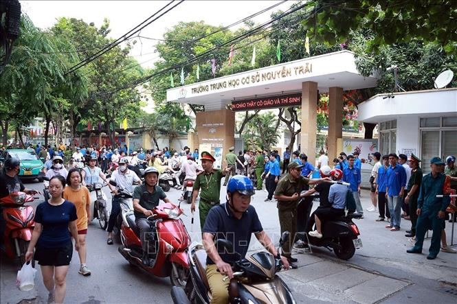 Lực lượng Công an phường Khương Đình làm nhiệm vụ đảm bảo an ninh trật tự, an toàn giao thông tại điểm thi Trường THCS Nguyễn Trãi. Ảnh: Phạm Kiên - TTXVN