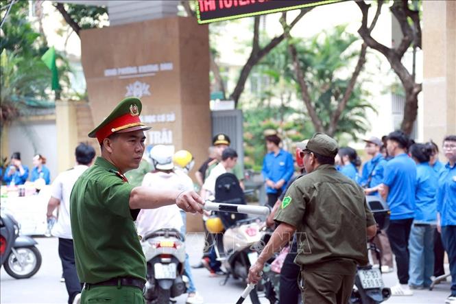 Lực lượng Công an phường Khương Đình làm nhiệm vụ đảm bảo an ninh trật tự, an toàn giao thông tại điểm thi Trường THCS Nguyễn Trãi. Ảnh: Phạm Kiên - TTXVN