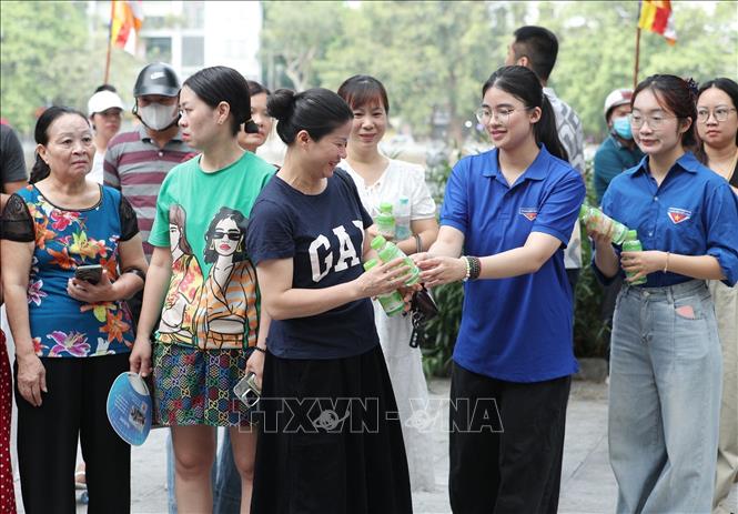 Thanh niên Thủ đô phát nước miễn phí tới thí sinh và phụ huynh tại điểm thi trường THPT Trần Nhân Tông. Ảnh: Minh Đức – TTXVN
