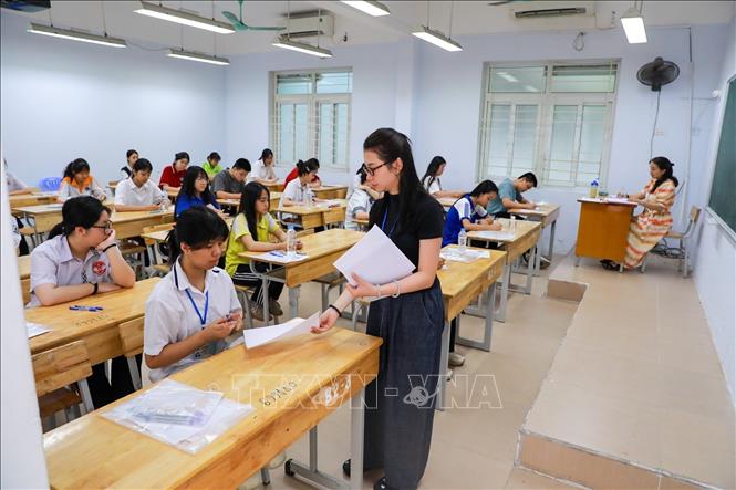 Giám thị phát giấy nháp cho thí sinh tại Điểm thi trường THPT Đoàn Kết - Hai Bà Trưng (phường Bạch Mai). Ảnh: Khánh Hoà - TTXVN