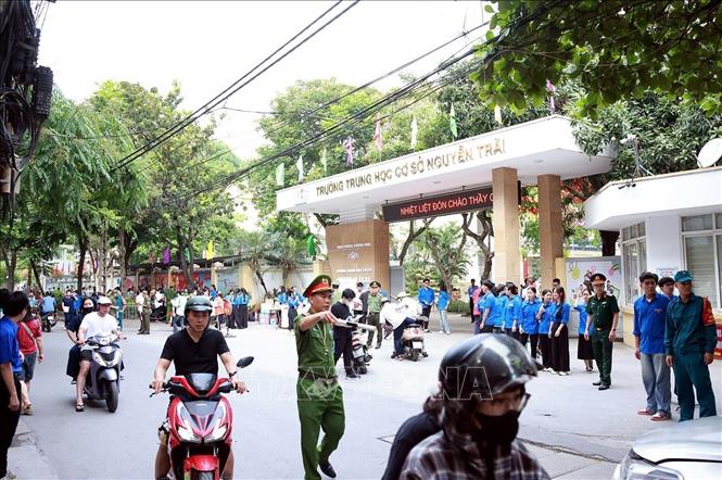 Lực lượng Công an phường Khương Đình làm nhiệm vụ đảm bảo an ninh trật tự, an toàn giao thông tại điểm thi Trường THCS Nguyễn Trãi. Ảnh: Phạm Kiên - TTXVN