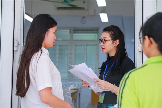 Giám thị kiểm tra thông tin thí sinh trước khi vào phòng thi tại Điểm thi trường THPT Đoàn Kết - Hai Bà Trưng (phường Bạch Mai). Ảnh: Khánh Hoà - TTXVN