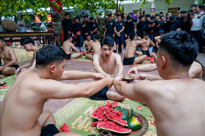 Nghi thức uống rượu ăn dưa trước khi trận vật cầu nước diễn ra. Ảnh: Khánh Hoà - TTXVN