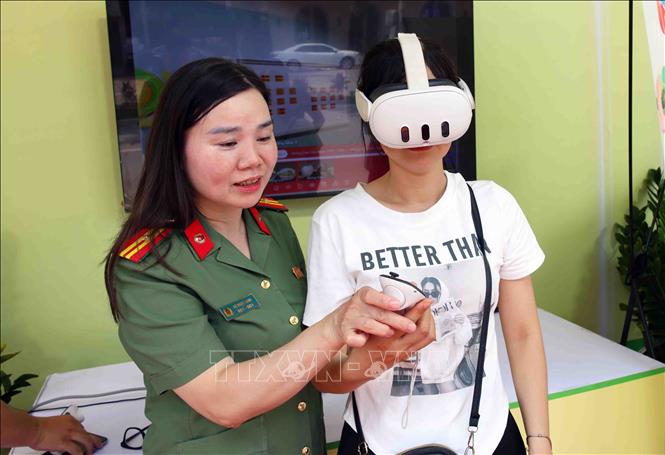Người dân trải nghiệm ứng dụng công nghệ số trong lực lượng Công an thành phố Hà Nội. Ảnh: Phạm Kiên - TTXVN