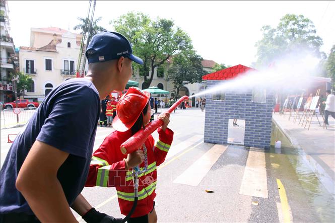 Các em nhỏ thích thú được trải nghiệm làm lính cứu hỏa. Ảnh: Phạm Kiên - TTXVN