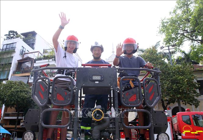Du khách quốc tế hào hứng tham gia các hoạt động trải nghiệm PCCC và CNCH. Ảnh: Phạm Kiên - TTXVN