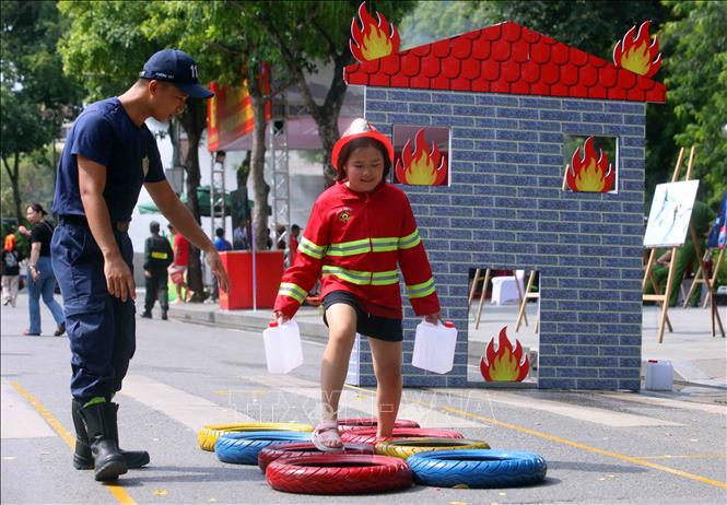 Các em nhỏ thích thú được trải nghiệm làm lính cứu hỏa. Ảnh: Phạm Kiên - TTXVN