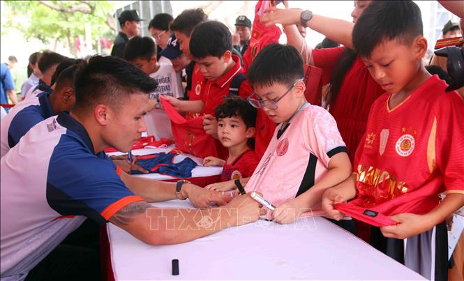 Người dân và các em nhỏ hào hứng giao lưu, xin chữ ký các cầu thủ CLB bóng đá Công an Hà Nội tại buổi lễ. Ảnh: Phạm Kiên - TTXVN