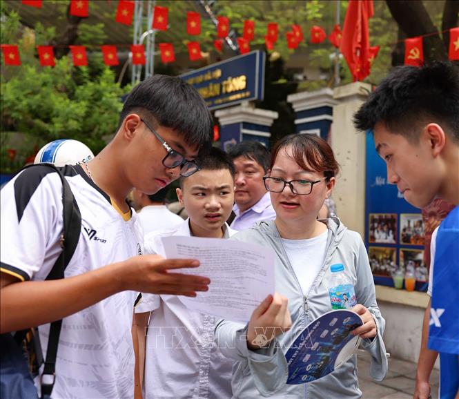 Thí sinh trao đổi sau khi hoàn thành môn thi đầu tiên tại điểm thiTrường THPT Trần Nhân Tông . Ảnh: Thanh Tùng - TTXVN