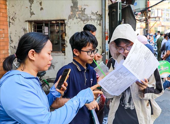 Phụ huynh chia sẻ cảm xúc với thí sinh sau khi hoàn thành môn thi Ngoại ngữ tại điểm thi trường THCS Ngô Quyền (phường Bạch Mai). Ảnh: Khánh Hoà - TTXVN