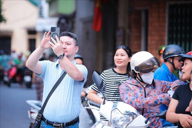 Phụ huynh chờ đợi, lưu lại khoảnh khắc thí sinh vào điểm thi trong Kỳ thi tuyển sinh lớp 10 công lập tại Hà Nội. Ảnh: Hoàng Hiếu - TTXVN 